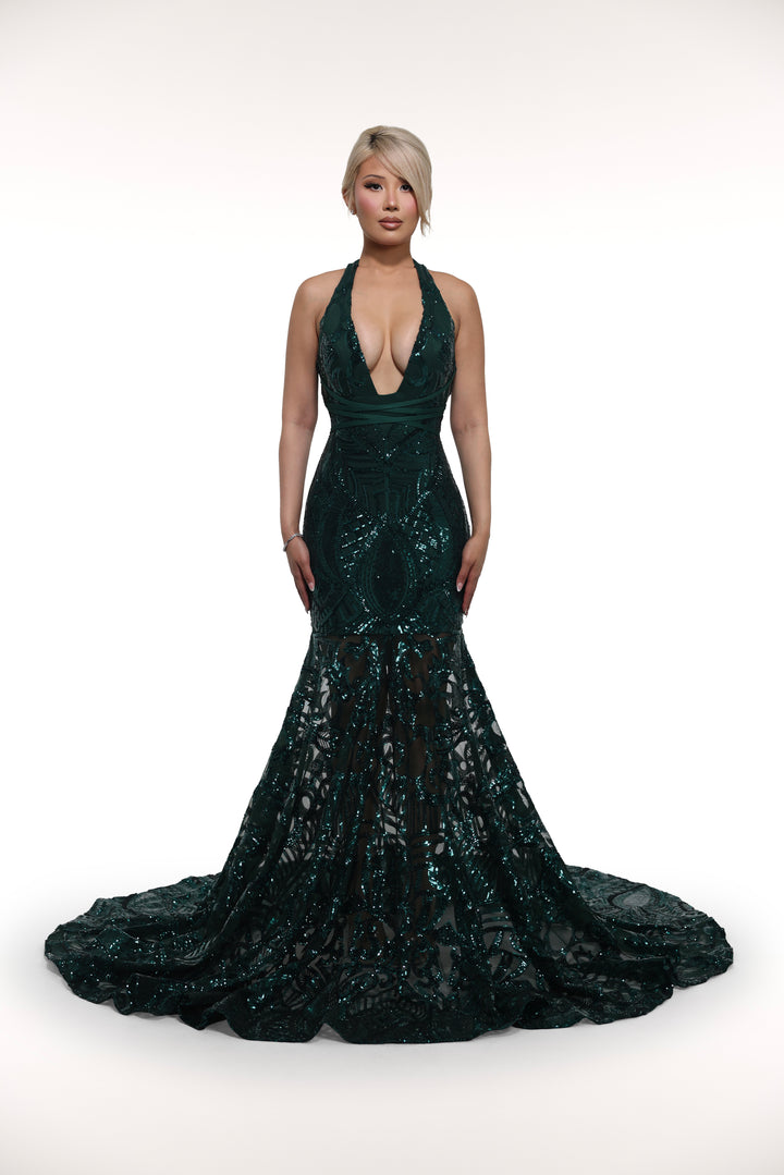 Woman wearing a dark green sequin gown on a white background