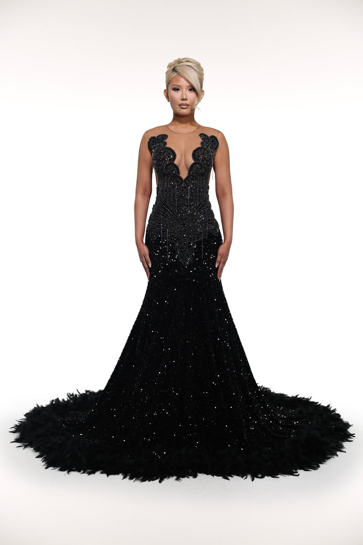 Black evening gown with intricate detailing on a white background