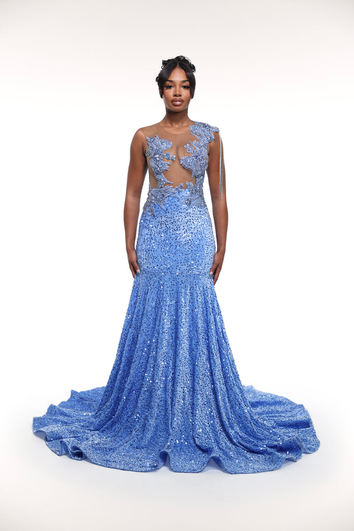 Woman wearing a blue evening gown with intricate detailing on a white background