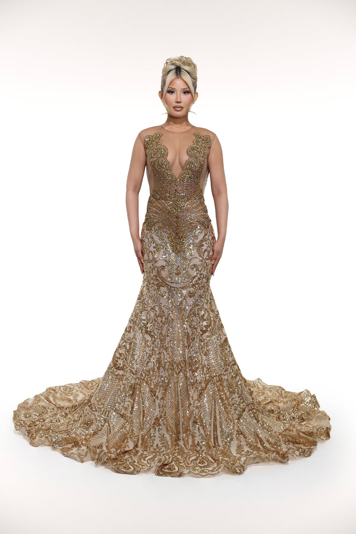 Woman wearing a gold evening gown with a deep neckline on a white background