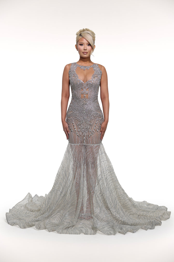 Woman wearing a silver beaded evening gown on a white background